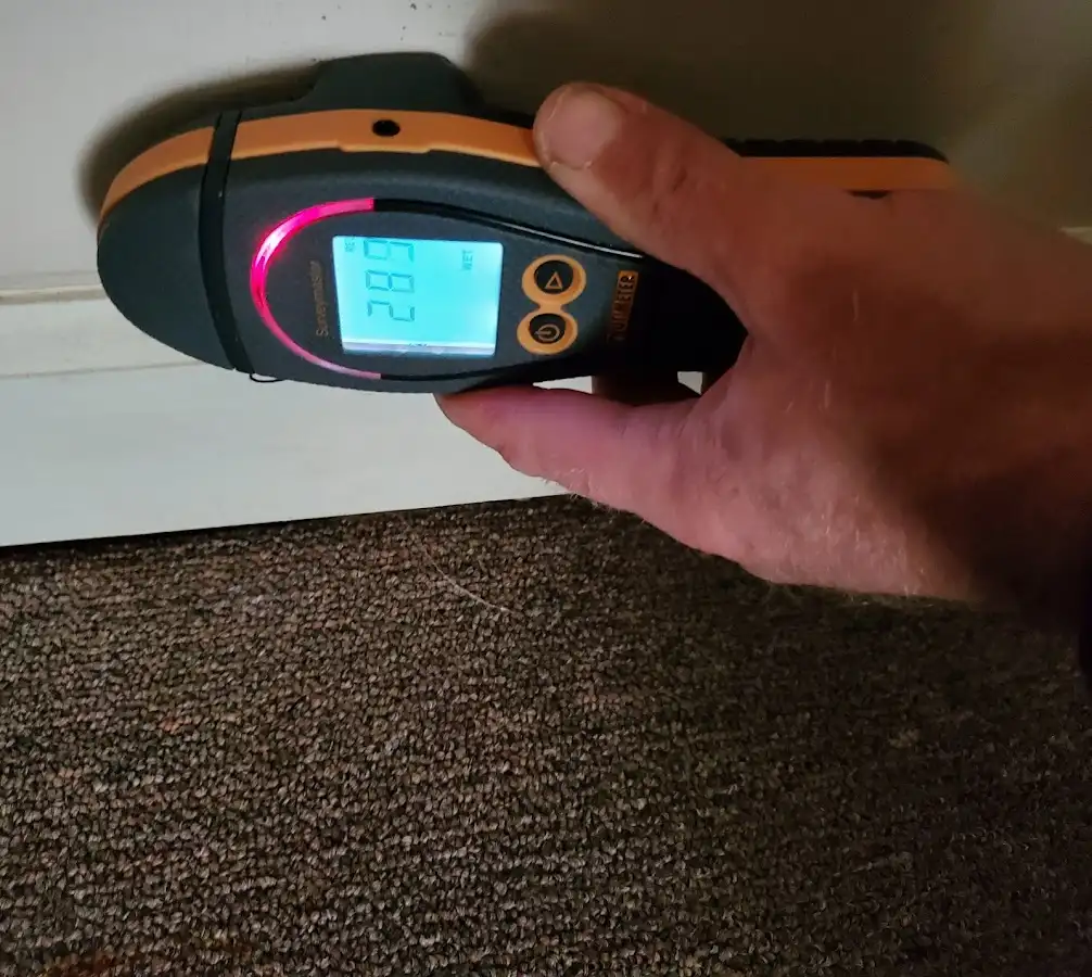 Moisture detection at baseboard during Storm Damage Restoration in New Burlington